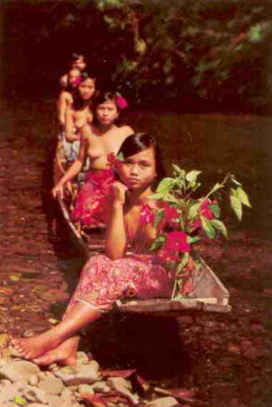 Sarawak, Dayak beauties rowing canoe on the river