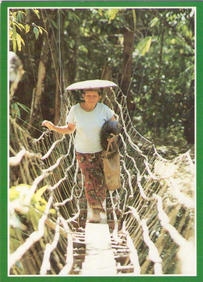 Orang Ulu woman using typical foot-bridge, rural Sarawak